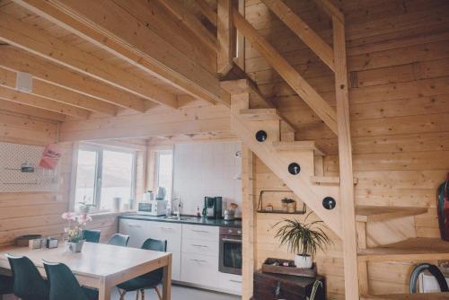 a kitchen and dining room in a log cabin at Fjordcottage in Søldarfjørður