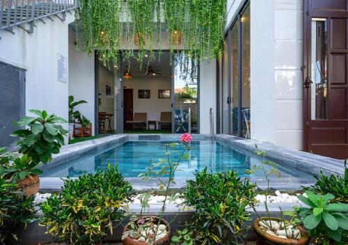 een zwembad in het midden van een huis met planten bij Le Printemps d' An Bang in Hội An