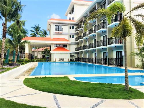 un hotel con piscina frente a un edificio en Costa Palawan Resort, en Puerto Princesa City