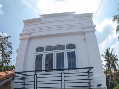 a white house with a fence in front of it at NHÀ NGHỈ HOA PHÁT in Phu Quoc