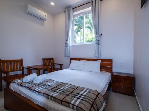 a bedroom with a large bed and a window at NHÀ NGHỈ HOA PHÁT in Phu Quoc
