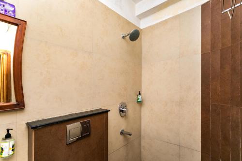 y baño con ducha, puerta y espejo. en Le Celestium, en Munnar