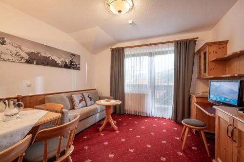 a living room with a couch and a table at Apparthotel Ederfeld in Mayrhofen