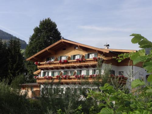 a house with flowers on the balconies of it at Gourmet-Hotel Grünwald in Leogang