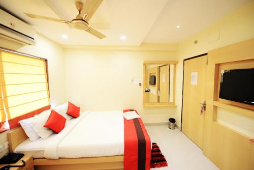 a bedroom with a bed and a flat screen tv at Hotel Saad in Kolkata