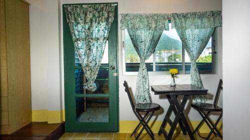una porta verde con tavolo e finestra di Sabina Guesthouse Kamala a Kamala Beach