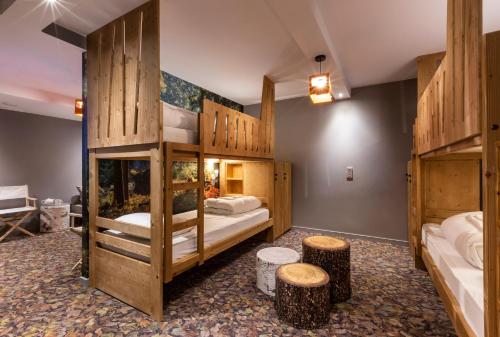 ブール・サン・モーリスにあるHotel Base Camp Lodge - Bourg Saint Mauriceの二段ベッド2台とスツール2台が備わる客室です。
