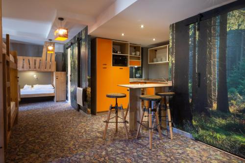a room with a bar and stools and a bedroom at Hotel Base Camp Lodge - Bourg Saint Maurice in Bourg-Saint-Maurice