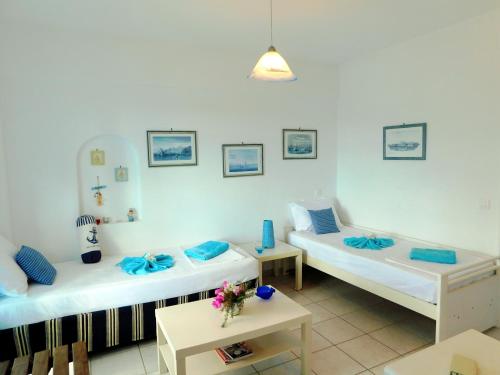 a room with two beds and a table at Thalia Apartment in Piso Livadi