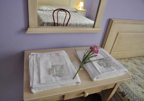 a table with towels on it with a mirror at Hotel Regina in Florence