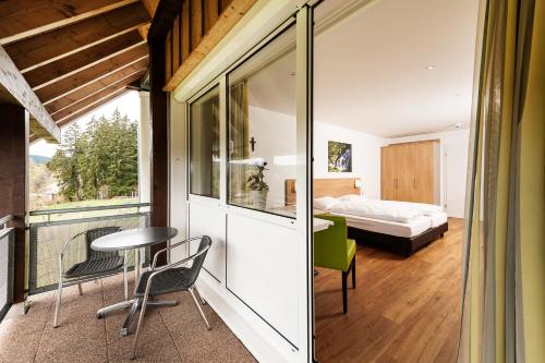 a room with a bed and a table and chairs at Haus Feldberg-Falkau in Feldberg