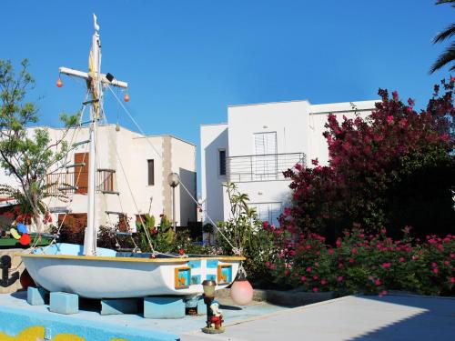 a small boat sitting in front of a building at Panorama Beach House, 5 meters to the sea in Perivolia