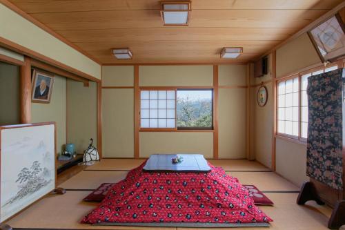 吉野的住宿－Houtouji Temple，一间设有红色床铺的客房,位于带窗户的房间内