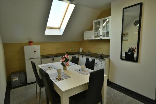 a kitchen with a white table with chairs and a window at Apartamenty Akacjowa Villa106 in Nędza