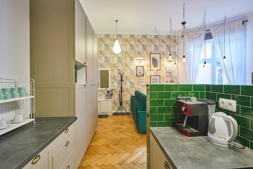 kuchnia z zielonymi płytkami na ladzie i urządzenia w obiekcie Kurkowa GamaHome Cozy Apartments w Krakowie