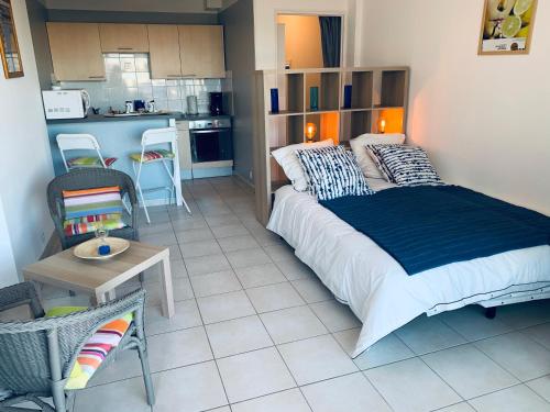 une chambre avec un grand lit et une cuisine dans l'établissement OntheRise Studio & terrasse vue mer - Palavas Centre, à Palavas-les-Flots