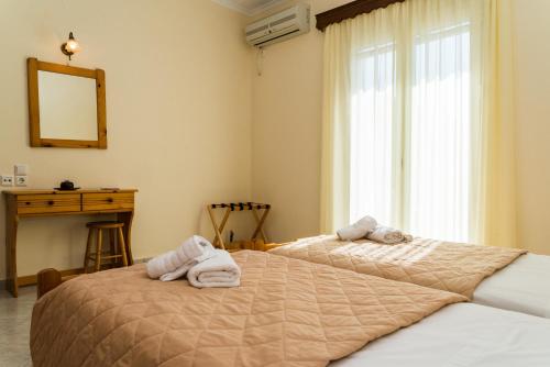 two beds in a bedroom with towels on them at Bratis Apartments in Keri