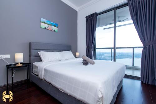 a bedroom with a white bed and a large window at R&F Princess Cove CIQ Premium Sea & City view Suites by NEO in Johor Bahru