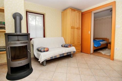 a living room with a wood stove and a chair at Ekološka turistična kmetija pri Lovrču in Tolmin