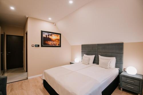 a bedroom with a large white bed and a chair at Mountain Paradise & Wellness in Izvoare