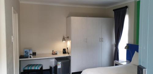a bedroom with a bed and a white cabinet at Premier Splendid Inn Bayshore in Richards Bay
