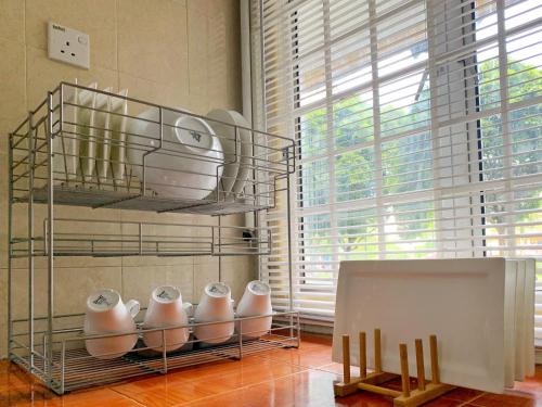 a kitchen with a shelf with a bunch of dishes at Maya Homestay Putrajaya in Putrajaya