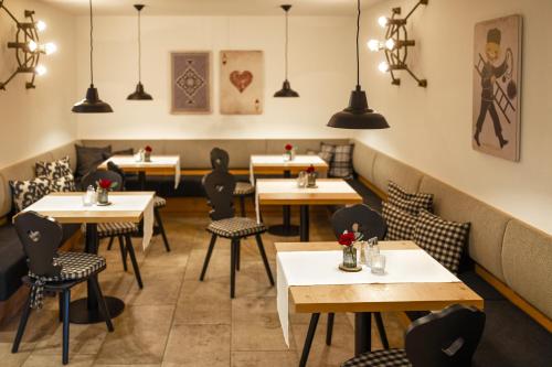 a restaurant with tables and chairs and pendant lights at HELDs Vitalhotel in Ruhpolding