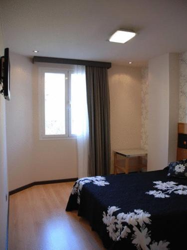 a bedroom with a bed and a window at Hostal de Cuenca in Cuenca