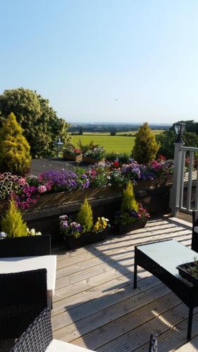 a wooden deck with a garden of flowers at Bed & Breakfast Fieldview in Rochester