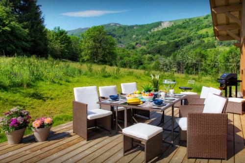 a wooden deck with a table and chairs on it at Chalet Pajules - OVO Network in Le Fey