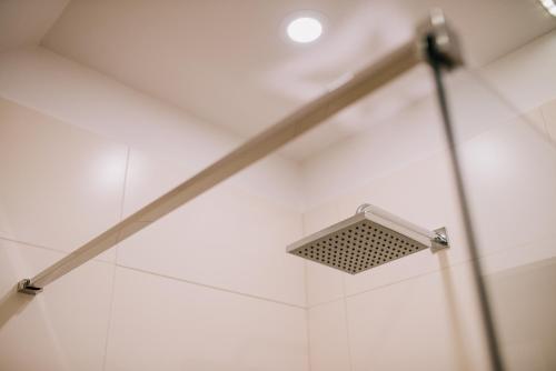 a light in a shower with white tile at Mountain Paradise & Wellness in Izvoare