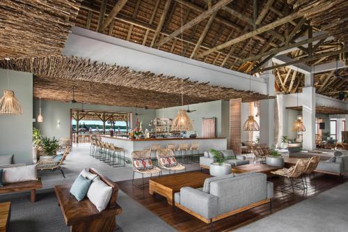 a lobby with couches and chairs and a bar at Preskil Island Resort in Blue Bay