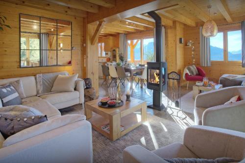 a living room with white couches and a fireplace at Chalet Tekoa - OVO Network in Manigod