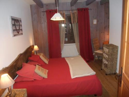 1 dormitorio con cama roja y cortinas rojas en Le Domaine du Grand Cellier Chambres d'hôtes en Savoie en Tournon