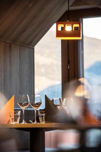 a table with wine glasses on it with a window at Hotel Base Camp Lodge - Bourg Saint Maurice in Bourg-Saint-Maurice