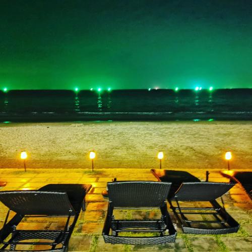 a group of chairs sitting on the beach at night at Mae Pim Dream Condo in Mae Pim