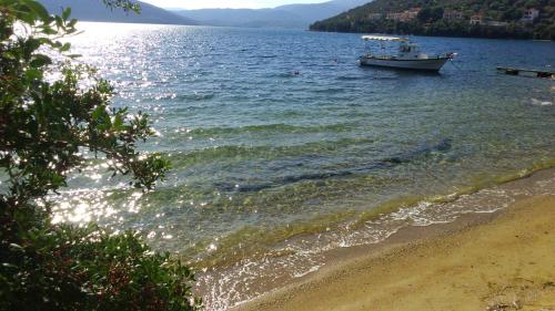 a boat in the water next to a beach at Haus Pigadi in Pteleós