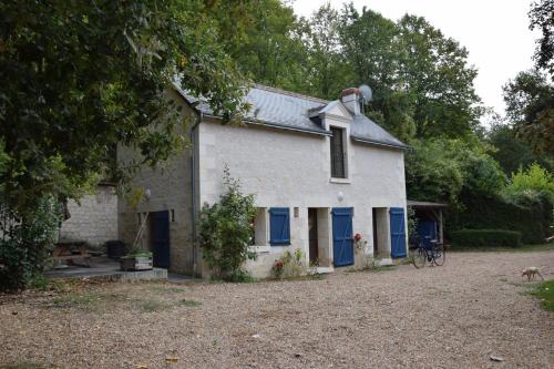 une maison blanche avec des portes bleues et un vélo devant dans l'établissement la Bergerie, à Panzoult