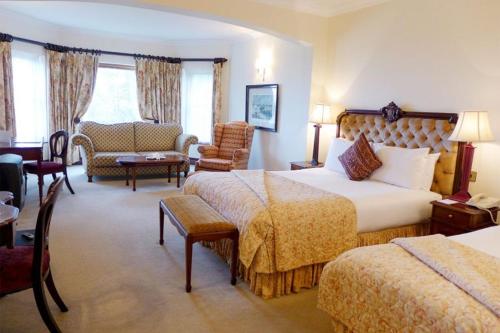 a hotel room with two beds and a living room at Tinakilly Country House Hotel in Rathnew