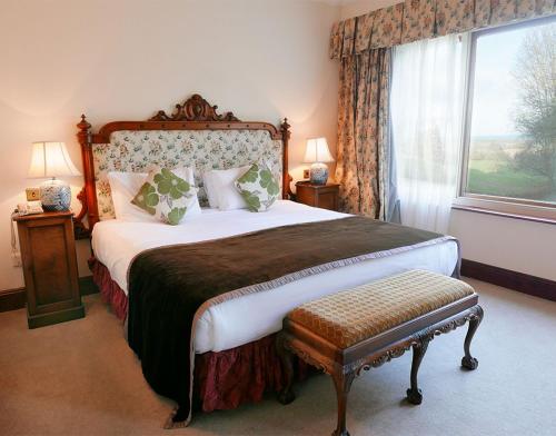 a bedroom with a large bed and a window at Tinakilly Country House Hotel in Rathnew