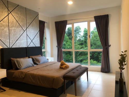 um quarto com uma cama com um urso de peluche sentado sobre ele em Santubong Suites A Just Like Home Damai em Kuching