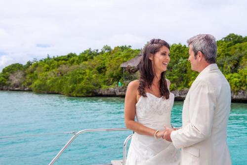 a man and woman standing next to each other on a boat at Preskil Island Resort in Mahébourg