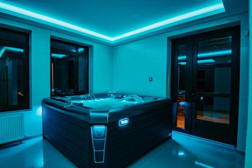 a bathroom with a tub with blue lighting at Mountain Paradise & Wellness in Izvoare