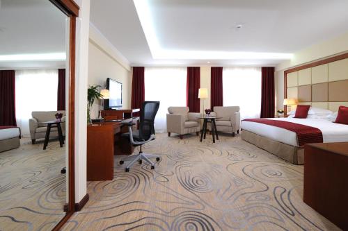 a hotel room with a bed and a desk at Kempinski Hotel Khan Palace in Ulaanbaatar