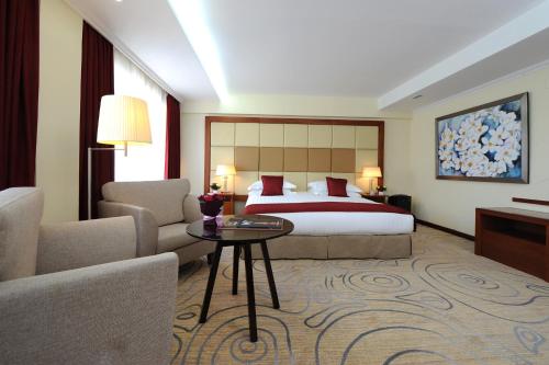 a hotel room with a bed and a couch and a table at Kempinski Hotel Khan Palace in Ulaanbaatar