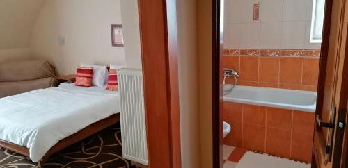 a bedroom with a bed and a bath tub at Pension Magnolia in Trenčín