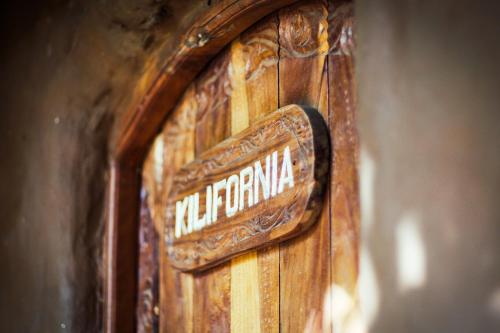 a wooden door with an old sign on it at Distant Relatives Ecolodge & Backpackers in Kilifi