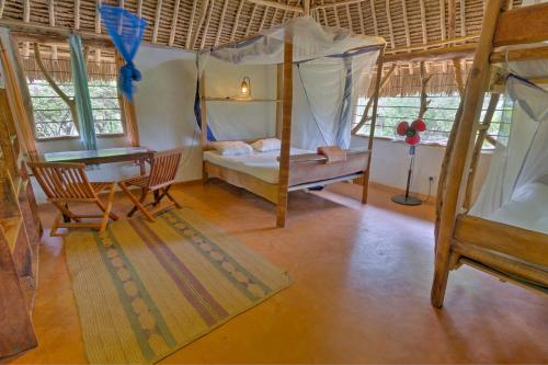 a room with two bunk beds and a desk at Distant Relatives Ecolodge & Backpackers in Kilifi