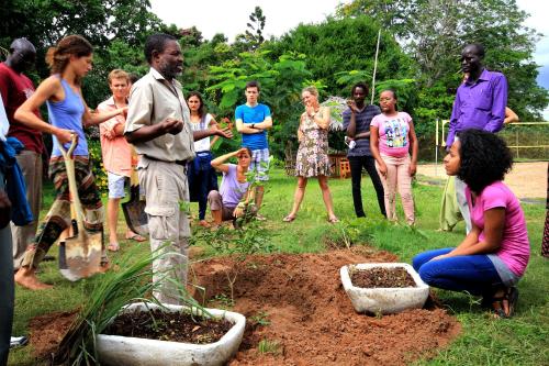 a group of people standing around a plant in a garden at Distant Relatives Ecolodge & Backpackers in Kilifi