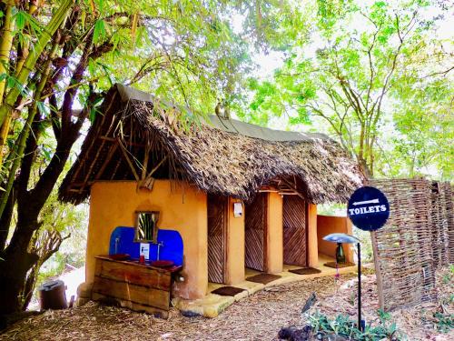 a small house with a thatched roof at Distant Relatives Ecolodge & Backpackers in Kilifi